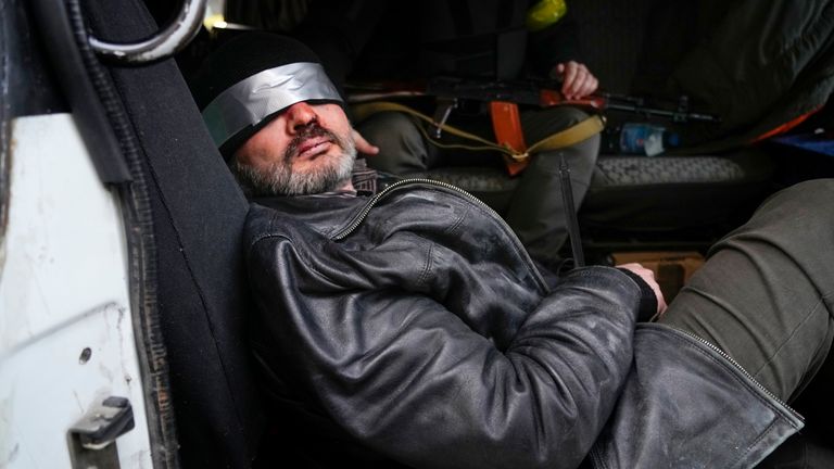 Ukrainian troops take into custody a man they suspect is a Russian agent. Pic: Associated Press 