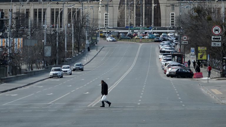 A resident crosses an empty street during a curfew, after Russia launched a massive military operation against Ukraine, in Kyiv, Ukraine February 27, 2022. REUTERS/Carlos Barria
