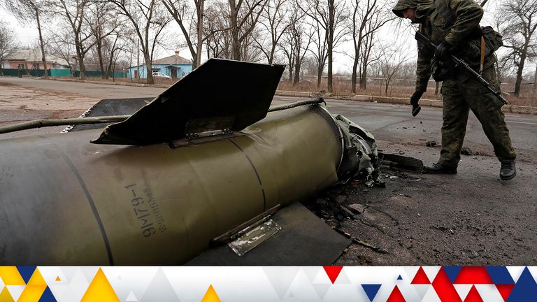 A militant of the self-proclaimed Donetsk People&#39;s Republic inspects the remains of a missile that landed on a street in the separatist-controlled city of Donetsk, Ukraine February 26, 2022. REUTERS/Alexander Ermochenko