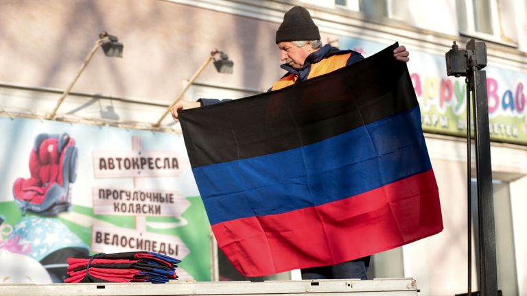A municipal worker prepares to put up a Donetsk People Republic flag on a building in Donetsk, a territory in eastern Ukraine controlled by pro-Russian militants