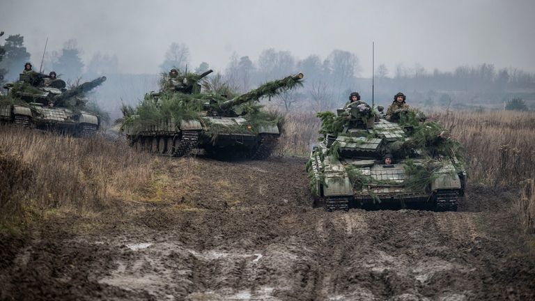 Ukrainian service members ride atop tanks during tactical drills at a training ground in an unknown location in Ukraine, in this handout picture released February 22, 2022. Press service of the Ukrainian Armed Forces General Staff/Handout via REUTERS ATTENTION EDITORS - THIS IMAGE HAS BEEN SUPPLIED BY A THIRD PARTY.
