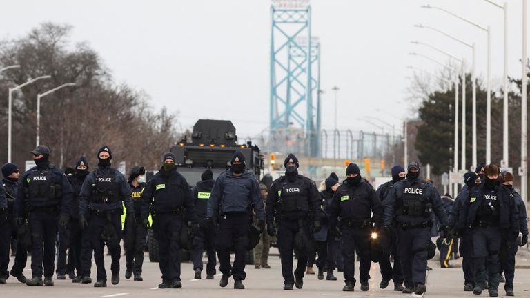 Police officers moved along a road leading to the Ambassador Bridge, which connects Detroit and Windsor