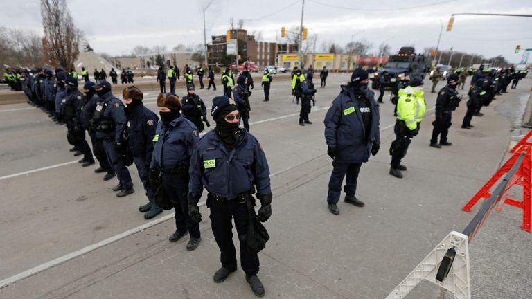Police officers were seen standing in a line on the road leading to the Ambassador Bridge