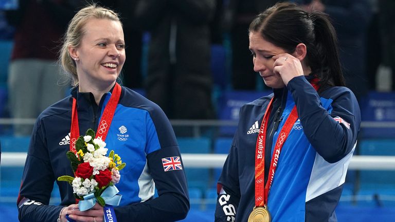 Eve Muirhead (R) wipes away a tear after after receiving her gold medal with teammate Vicky Wright