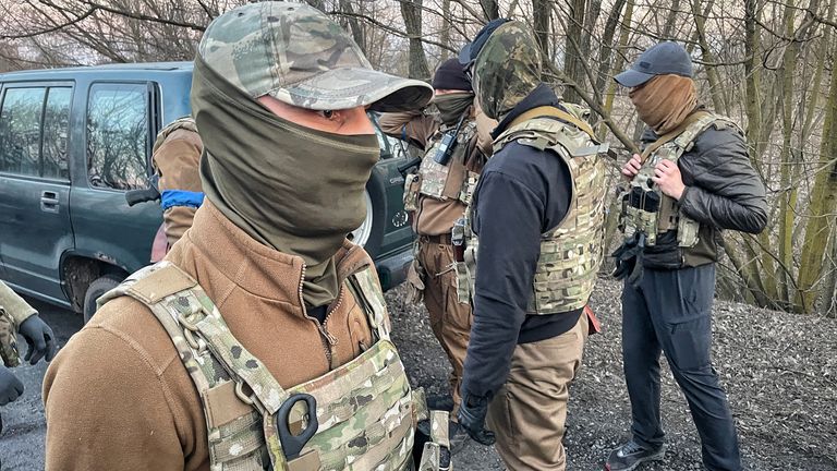 Volunteer soldiers discuss the best way to get back into the city to help evacuate more civilians 