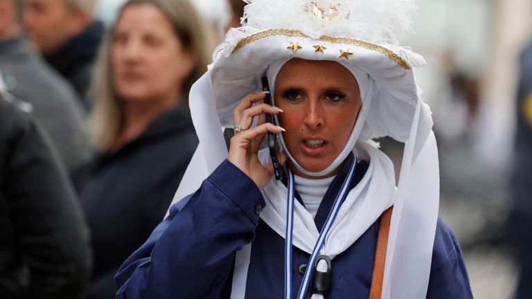 A performer speaks on a phone, after a car hit people in Strepy-Bracquenies, Belgium. Pic: AP