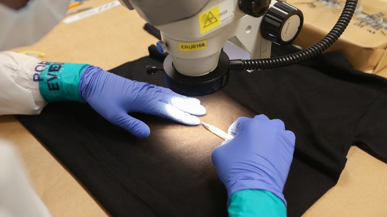 A Forensic Examiner uses a pen to gauge scale using the traditional method of blood detection