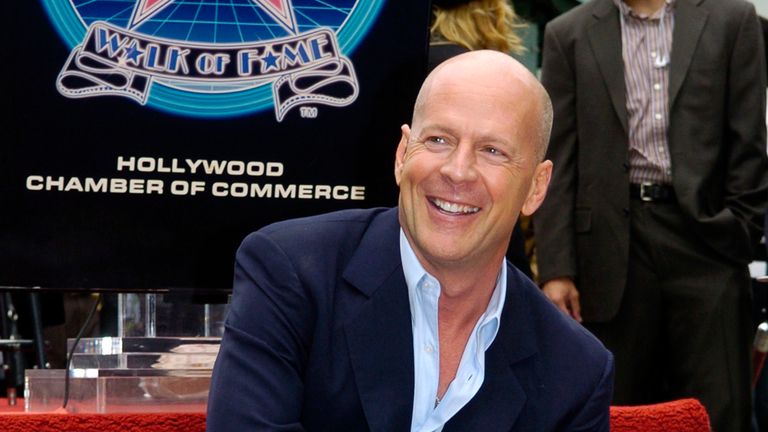 Actor Bruce Willis touches his new star on the Hollywood Walk of Fame in Los Angeles October 16, 2006. REUTERS/Chris Pizzello (UNITED STATES)
