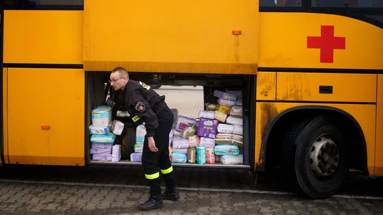 Bir gardiyan, Polonya'daki Przemysl'den Ukrayna'ya nakledecek olan İngiliz gönüllü Cliff Wilson'a ait bir otobüse yardım malzemeleri yüklüyor ve dönüşünde Ukraynalı kadın ve çocukları alıp sınırdan Polonya'daki güvenli bir yere geri getiriyor.  Resim tarihi: 30 Mart 2022 Çarşamba.