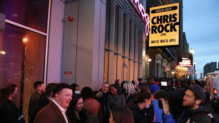 Fans are interviewed by members of the media as they wait in line outside the Wilbur Theatre in Boston