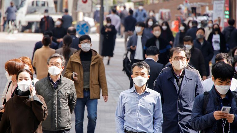 People wearing masks walk in a shopping district amid the coronavirus disease (COVID-19) pandemic in Seoul, South Korea, March 16, 2022. REUTERS/Heo Ran