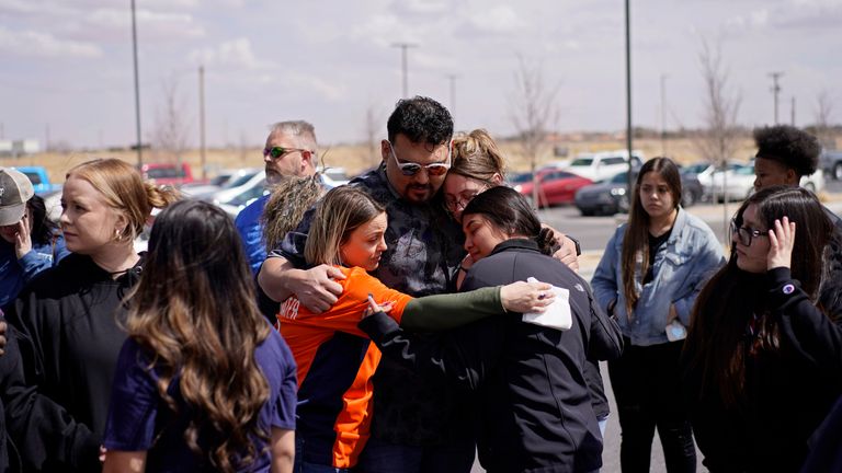 People console each other during a memorial for Jackson Zinn at a Texas Roadhouse restaurant, Thursday, March 17, 2022, in Hobbs, New Mexico. Zinn, who worked at the restaurant, was killed with several other student golfers and the coach of University of the Southwest in a crash in Texas. (AP Photo/John Locher)