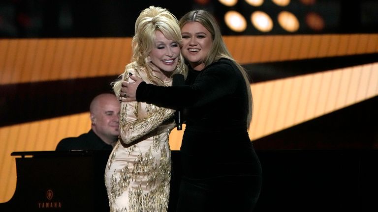 Dolly Parton, left, and Kelly Clarkson embrace onstage at the 57th Academy of Country Music Awards on Monday, March 7, 2022, at Allegiant Stadium in Las Vegas. (AP Photo/John Locher)


