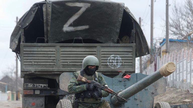 A service member of pro-Russian troops in a uniform without insignia walks past a truck with the letter "Z" painted on its tent top in the separatist-controlled settlement of Buhas (Bugas), as Russia&#39;s invasion of Ukraine continues, in the Donetsk region, Ukraine March 1, 2022. REUTERS/Alexander Ermochenko
