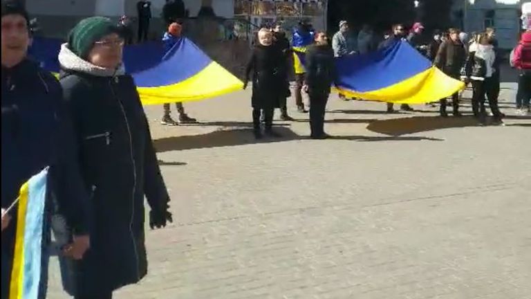 Les manifestants brandissent d'énormes drapeaux ukrainiens dans le centre de Kherson