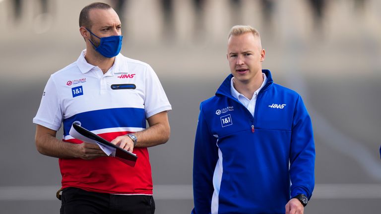 FILE - Haas driver Nikita Mazepin, right, of Russia and members of his team hit the track ahead of Sunday's Formula 1 Turkish Grand Prix at Intercity Istanbul Park track outside Istanbul, Turkey , Thursday October 7, 2021 The international motor racing body, the FIA, has said that Russian drivers like Nikita Mazepin can still compete, but a blockage of cars in national colors would prevent Mazepin's Haas team from bringing the livery back to stripes of the Russian flag which she removed.  during testing last week.  Russians