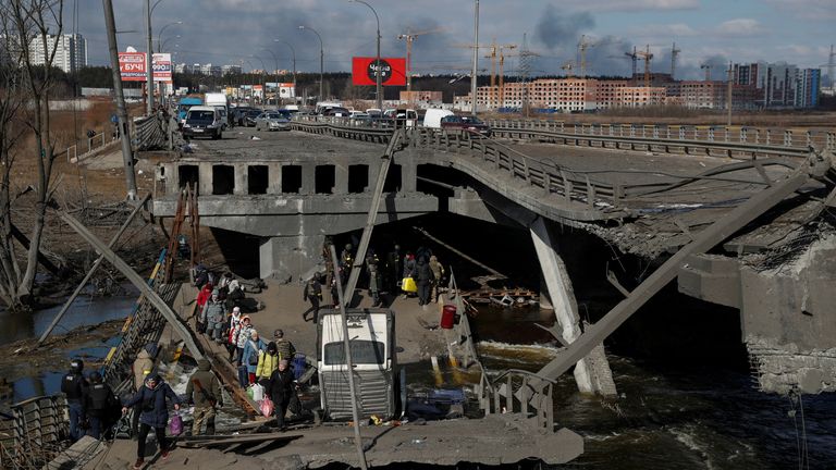 People cross the Irpin river next to a destroyed bridge as they evacuate from the Irpin town, as Russia&#39;s attack on Ukraine continues, outside of Kyiv, Ukraine March 10, 2022. REUTERS/Valentyn Ogirenko
