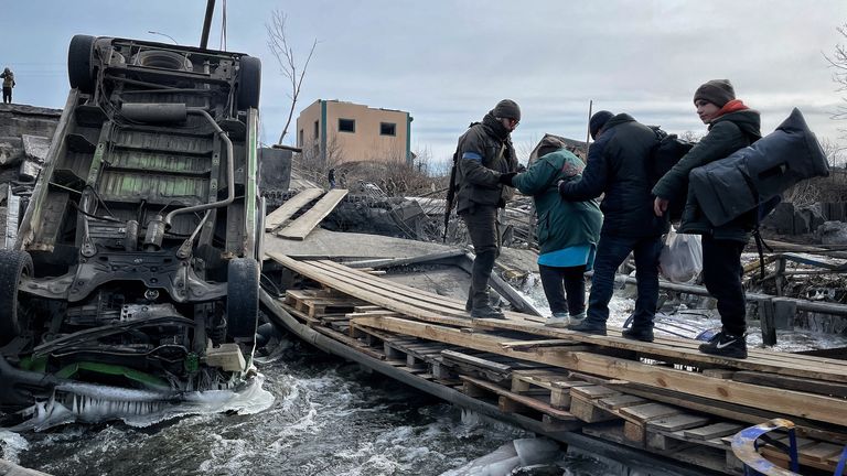 Irvine'den tahliye edilen aileler yıkılan bir köprüyü geçiyor