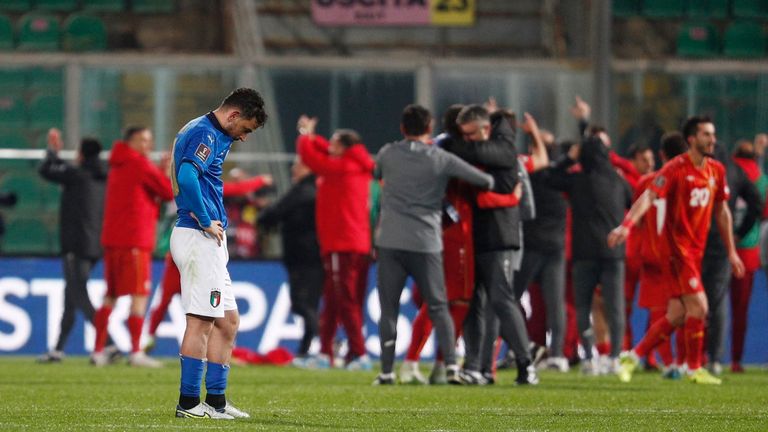 Italy&#39;s Alessandro Florenzi looks dejected after the match as North Macedonia celebrate