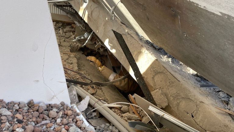 One of the rescuers searches under the debris