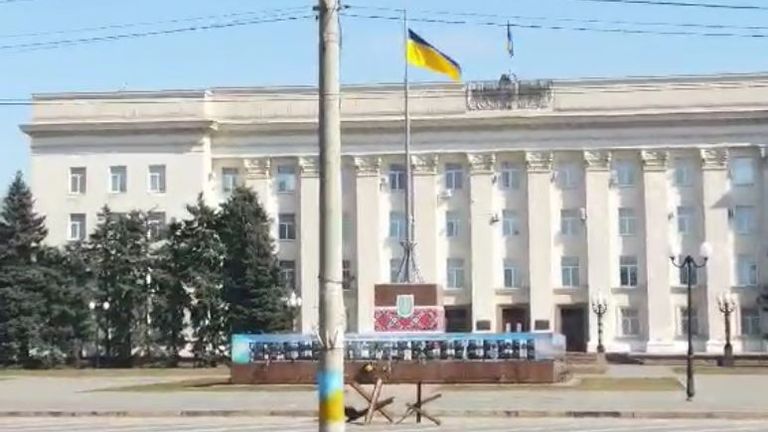 Un drapeau ukrainien flotte à l'extérieur d'un bâtiment dans le centre de Kherson
