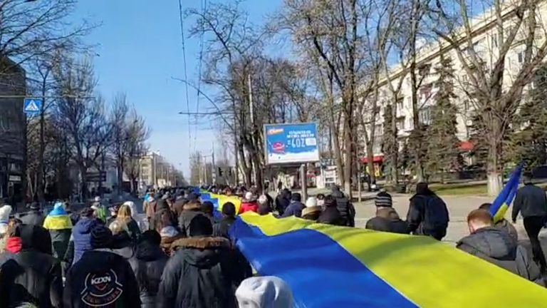 People carry a banner in the colours of the Ukrainian flag as they protest Russia&#39;s invasion of Ukraine in Kherson