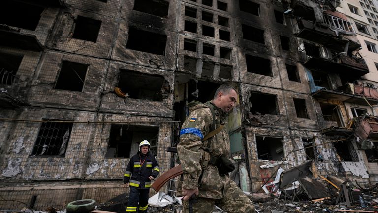 Ukrainian soldiers and firefighters search in a destroyed building after a bombing attack in Kyiv. Pic: AP