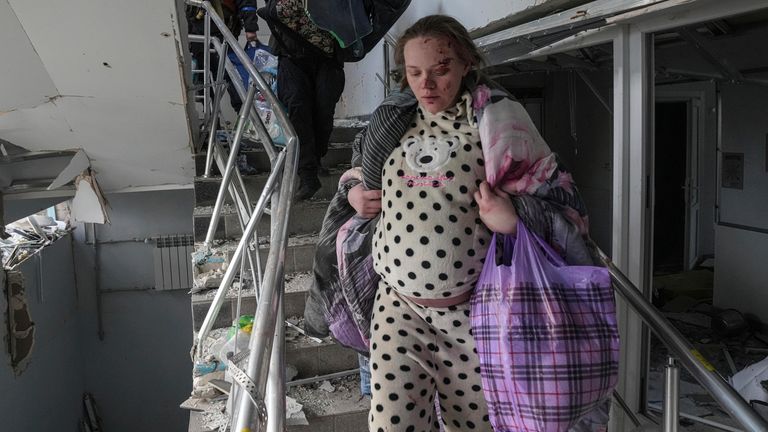 A heavily pregnant woman flees the wreckage of the maternity hospital in Mariupol Pic: AP