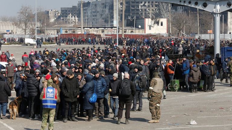 Люди выстраиваются в очередь во время доставки гуманитарной помощи возле поврежденного магазина оптовой компании «Метро» во время украинско-российского конфликта в осажденном южном портовом городе Мариуполь, 24 марта 2022 года.  REUTERS/Александр Ермоченко