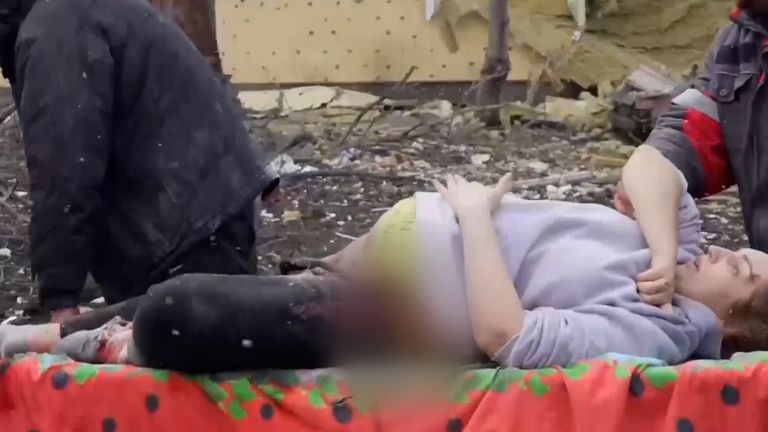 A pregnant woman is rushed to an ambulance in Mariupol