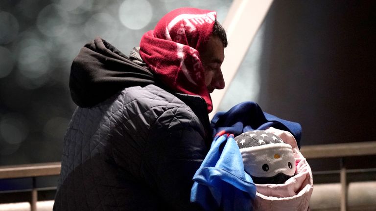 A man carries a baby as a group of people thought to be migrants are brought in to Dover, Kent, after being rescued by the RNLI following a small boat incident in the Channel. Picture date: Saturday January 15, 2022.