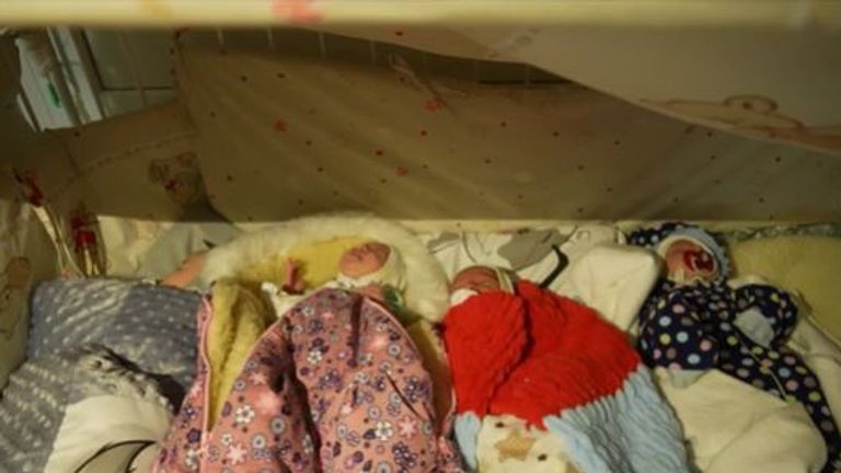 Newborn babies are sleeping in cribs covered by blankets to protect them from glass shattered during shelling