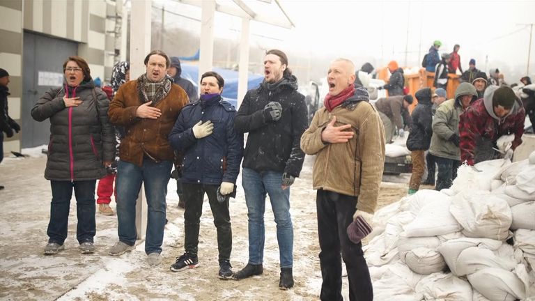 A choir sings the Ukrainian national anthem in the wind and the snow