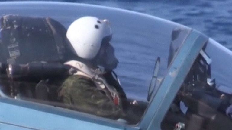 A pilot sits in the cockpit of an aircraft