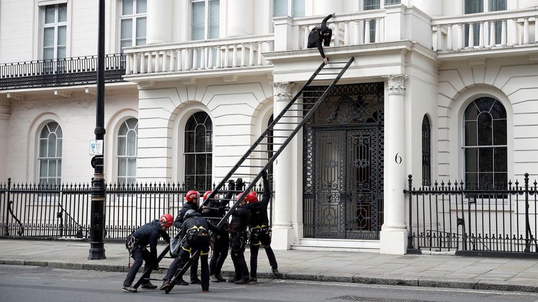 A protestor tries to push away a ladder being used by police officers as they attempt to enter a building next to the mansion reportedly belonging to Russian billionaire Oleg Deripaska, who was placed on Britain&#39;s sanctions list last week, as squatters occupy it, in Belgravia, London, Britain, March 14, 2022. REUTERS/Peter Nicholls      TPX IMAGES OF THE DAY     