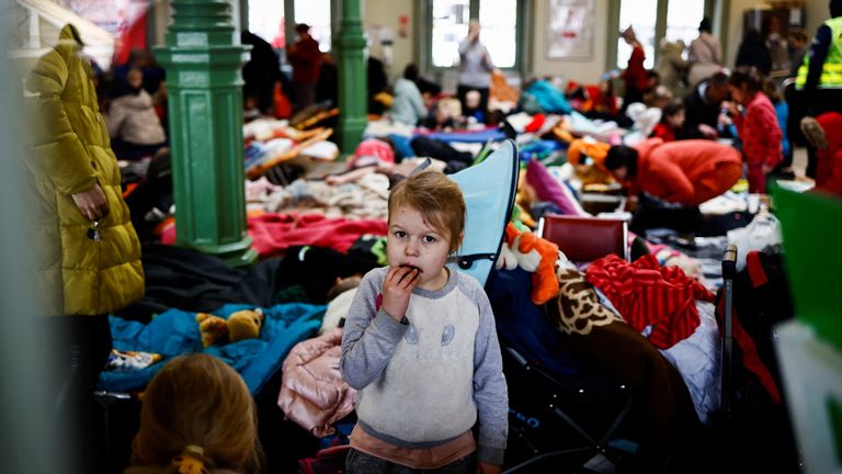  A child eats a cookie as she stands in a temporary accommodation for refugees at the train station, after fleeing Russian invasion of Ukraine, in Przemysl, Poland, March 7, 2022. REUTERS/Yara Nardi/File Photo