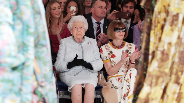 Queen Elizabeth sits with Vogue fashion editor Anna Wintour in the front row at London Fashion Week in 2018. Pic: AP