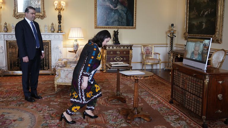 Queen Elizabeth II appears on a screen via videolink from Windsor Castle, where she is in residence, during a virtual audience to receive Her Excellency Rukhshona Emomali, Ambassador of the Republic of Tajikistan, and her husband Shamsullo Sohibov, at Buckingham Palace, London. Picture date: Tuesday March 15, 2022.
