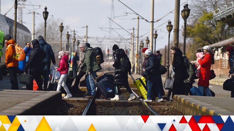 Refugees walk across train tracks to board a train to Bucharest at Suceava train station after fleeing Ukraine to the Siret border crossing in Romania, following Russia&#39;s invasion of Ukraine, in Suceava, Romania, March 17, 2022. REUTERS/Clodagh Kilcoyne