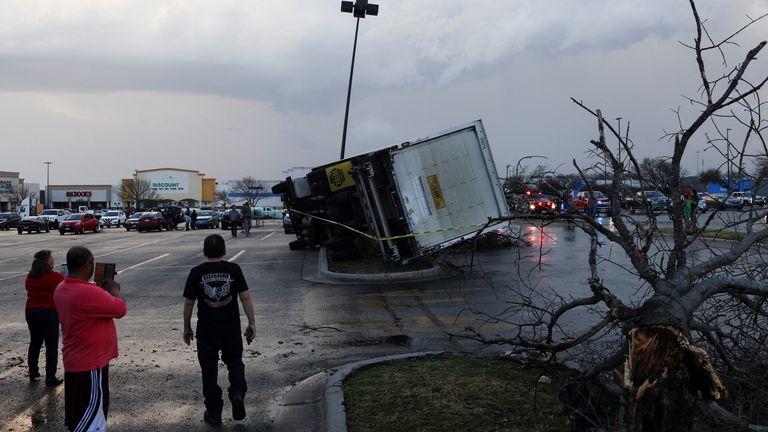 People look at an overturned truck in a parking lot after a tornado in a widespread storm system touched down in Round Rock, Texas, U.S., March 21, 2022. REUTERS/Tamir Kalifa
