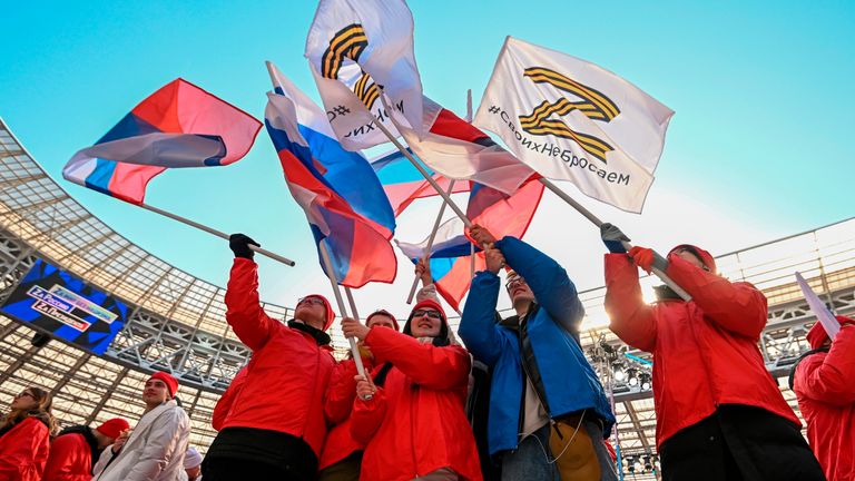 People wave Russian national flags and flags with the letter Z. Pic: AP