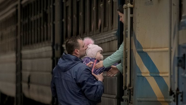 
A man hands a child to a woman before she boards a Lviv bound train, in Kyiv, Ukraine, Saturday, March 12, 2022. Fighting raged in the outskirts of Ukraine&#39;s capital, Kyiv, and Russia kept up its bombardment of other resisting cities. (AP Photo/Vadim Ghirda)