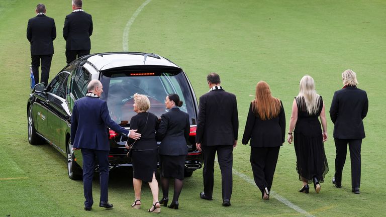 Family and friends follow the hearse at St Kilda Football Club in Melbourne