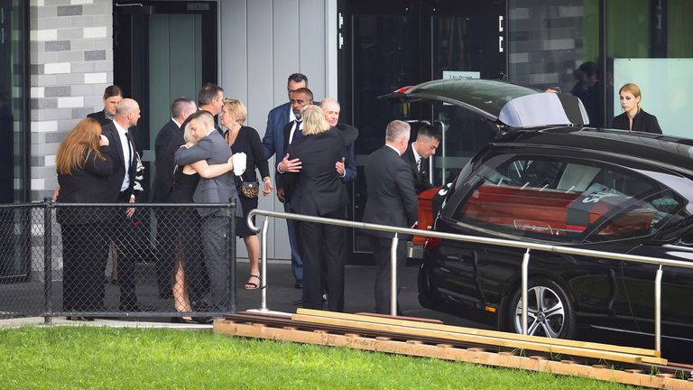 Warne's coffin is placed in the hearse