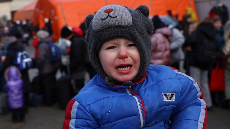 A young boy cries sitting on the shoulders of his brother as they search for their mother after fleeing the ongoing Russian invasion of Ukraine, outside the train station in Lviv, Ukraine, March 8, 2022. REUTERS/Kai Pfaffenbach
