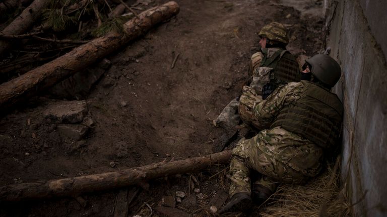 Des soldats ukrainiens se mettent à l'abri des tirs d'artillerie entrants à Irpin, dans la périphérie de Kiev, en Ukraine, le dimanche 13 mars 2022. (AP Photo/Felipe Dana)