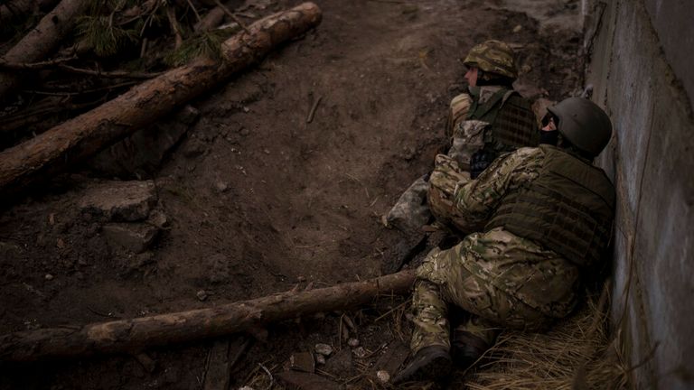 Ukraynalı askerler, 13 Mart 2022 Pazar, Ukrayna, Kiev'in eteklerindeki Irbin'de gelen topçu ateşinden saklanıyorlar (AP Photo/Felipe Dana)