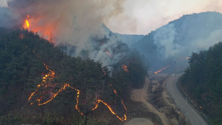 A wildfire burns on a mountain in Uljin, South Korea, Saturday, March 5, 2022. South Korea was deploying nearly 2,000 firefighters and troops on Saturday to battle a large wildfire that tore through an eastern coastal area and temporarily threatened a nuclear power station and a liquified natural gas plant. (Kim Huyn-tae/Yonhap via AP)