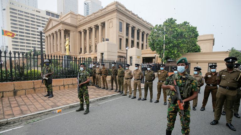 Special Task Force members stand guard at the main entrance of the President's secretariat as people block the main road in front of it during a protest organised by main opposition party Samagi Jana Balawegaya against the worsening economic crisis that has brought fuel shortages and spiralling food prices in Colombo, Sri Lanka March 15, 2022. REUTERS/Dinuka Liyanawatte

