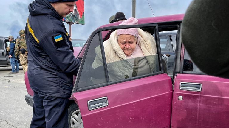 An elderly woman being helped out of a car in Irpin, Ukraine 